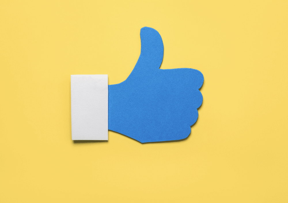 social media like icon in blue on yellow background